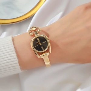 Macro view of gold quartz watch with black roman dial and luxury metal bracelet