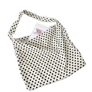 Minimalist white canvas tote bag with black polka dots and small MISS label tag