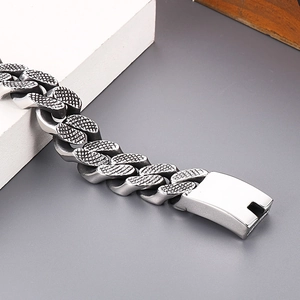 Close-up of silver-gray stainless steel Cuban chain bracelet with dragon scale texture