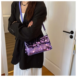 Detail of a purple sequin crossbody bag showing the glitter texture and slim strap