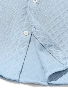 Detail of sky blue knitted texture and white buttons on a casual long sleeve shirt