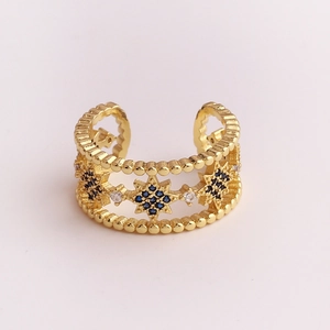 Macro detail of gold eight-pointed star ring with micro-set blue and clear zircons