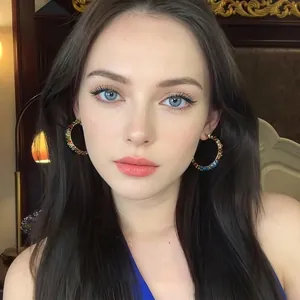 Close-up of elegant teardrop earrings with colorful stones worn by a woman for resort style