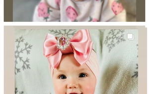 Pink satin bow headband for infants with a central crystal gemstone and wide elastic strap