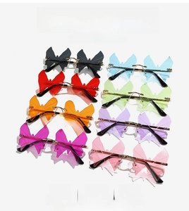 Close-up of rimless butterfly sunglasses in eight vibrant colors with gold metal bridges