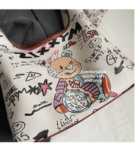 Détail du sac en cuir grainé blanc avec imprimés oursons et bordures marron