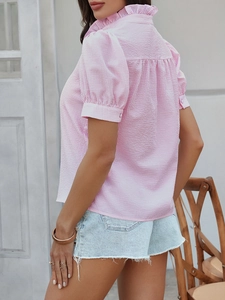 Detalle de camisa de rayas rosas y blancas con cuello volante y mangas abullonadas