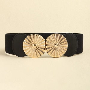 Detail of a black elastic waist belt featuring a radiant gold circular metal buckle