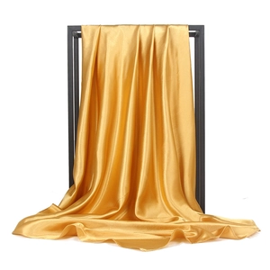 Detail eines goldenen Satin-Schals am Rahmen zeigt die seidig glatte Textur