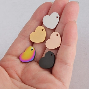 Hartvormige hangers in zilver, goud, roségoud, zwart en regenboog op een handpalm