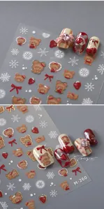 Detail macro view of 3D bear and strawberry nail art stickers with gold foil finish