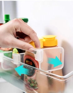 Detail view of adjustable refrigerator divider clips being installed on a side shelf rack