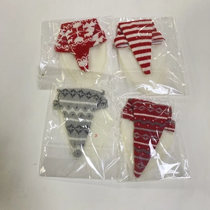 Detail of four knit Christmas gnome bottle covers with snowflake and striped patterns