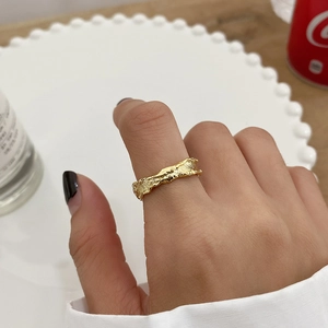 Detailed close-up of golden S925 sterling silver ring with irregular lava-like texture