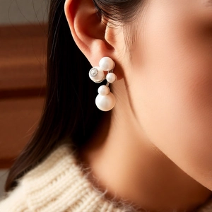 Close-up of cluster pearl earrings with crystals on an elegant model's ear