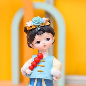 Close-up of cute girl figurine in blue hanfu with rose hairpiece and candied haws