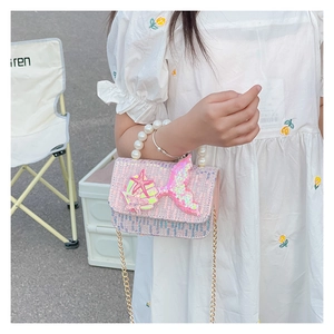 Detail of girl's sequin handbag with pearl handle, mermaid tail, and starfish charms