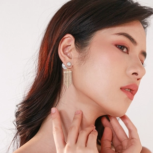 Elegant pearl earrings with rhinestone tassels shown on a model for a luxury style