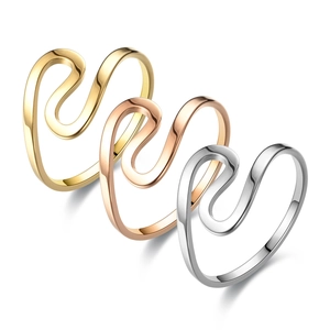 Detailed view of polished wave-shaped stainless steel rings in gold, silver, and rose gold