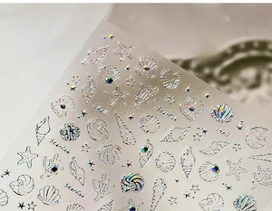 Macro detail of laser silver starfish and shell nail stickers with tiny rhinestones