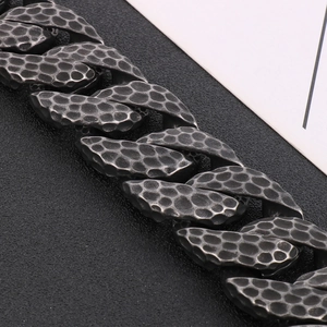 Detailed close-up of vintage hammer texture on retro steel cuban link chain bracelet