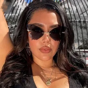 Close-up of stylish rimless butterfly sunglasses with dark grey lenses on a female model