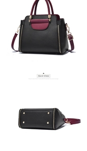 Detailed view of bicolor leather handbag with gold zippers and protective bottom studs