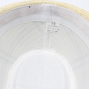 Detailed close-up of straw sun hat interior showing 100% paper material and size label