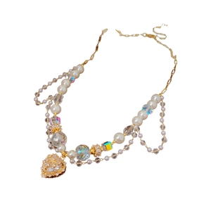 Elegant gold double-layered necklace featuring white pearls, crystals, and rhinestone hearts