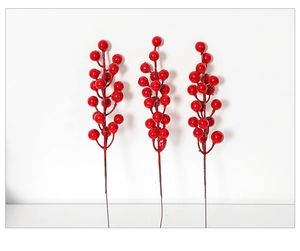 Detail shot of three realistic artificial red berry stems with glossy foam berries