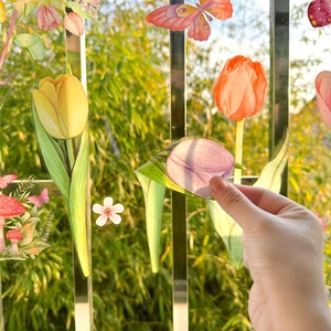 Detail showing the application of double-sided floral spring window clings to glass