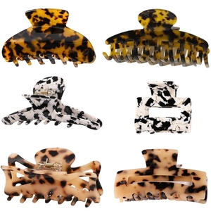 Detail view of 6-piece acetate hair claw set featuring tortoiseshell and cow patterns