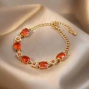 Bracelet plaqué or élégant avec cristaux ovales orange-rouge et breloques de fleurs