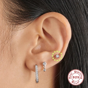 Detailed view of S925 sterling silver stud earring set with white zircon on ear cartilage