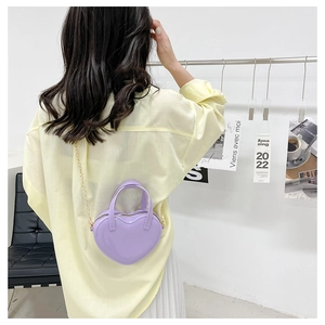 Detailed view of lavender heart-shaped jelly bag with gold chain strap on model