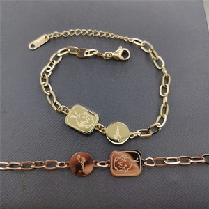 Detailed shot of Lucky charm and rabbit pendant on gold stainless steel bracelet