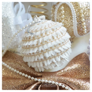 Macro shot of champagne gold Christmas ball ornaments with white tassels and pearl details
