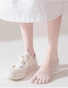 Dettaglio calzini rosa traspiranti a cinque dita con scarpe di tela e rete leggera