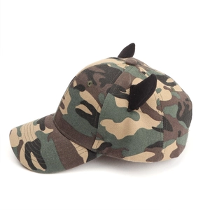 Detail of woodland camouflage baseball cap featuring 3D black devil horns on canvas