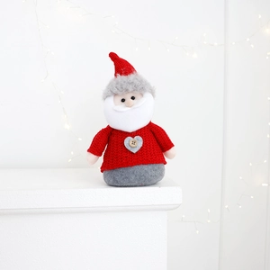 Detail of knitted Santa figurine with red sweater and grey base for Christmas decor