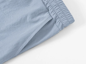 Detail view of light blue elastic waistband and side pocket on nylon blend cargo shorts