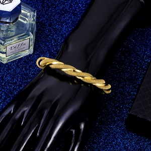Polished gold twisted cable stainless steel cuff bracelet shown on a model hand