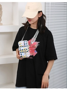 Detailed view of colorful plaid Oxford fabric phone crossbody bag with silver heart zipper
