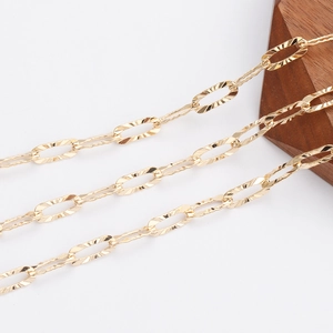 Detail of 18K gold-plated textured oval link chain on a wooden minimalist display