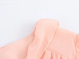 Close-up of pink ruffled chiffon fabric showing delicate stitching and pleat texture