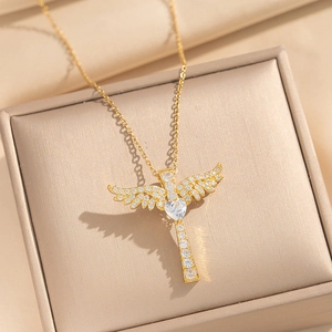 Gold plated angel wing cross necklace with heart zircon on a premium jewelry box display