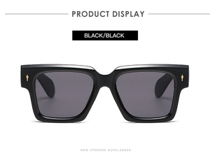 Close-up of vintage square black sunglasses with iconic gold metal rivet accents