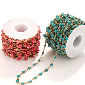 Detailed macro of pink and turquoise enamel heart-shaped stainless steel jewelry chains