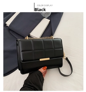 Detail of black quilted leather shoulder bag with gold chain strap and rectangular clasp