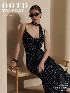 Close-up of black and white polka dot silk fabric texture on a slim fit maxi dress